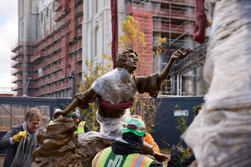 El escultor Michael Hall ayuda a colocar la estatua de la Primera Visión en la Manzana del Templo el miércoles, 6 de noviembre de 2024.