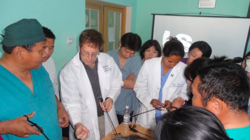 El Dr. Raymond R. Price, segundo desde la izquierda, muestra instrumentos laparoscópicos a cirujanos en el programa de Apoyo Vital Avanzado en Trauma (ATLS) en Mongolia, que comenzó en junio de 2015.