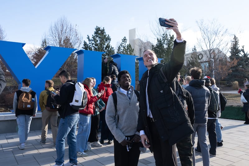 Estudiantes de BYU–Idaho se toman selfis con el nuevo monumento de letras de bloque BYUI inaugurado en el campus el 10 de diciembre de 2024.