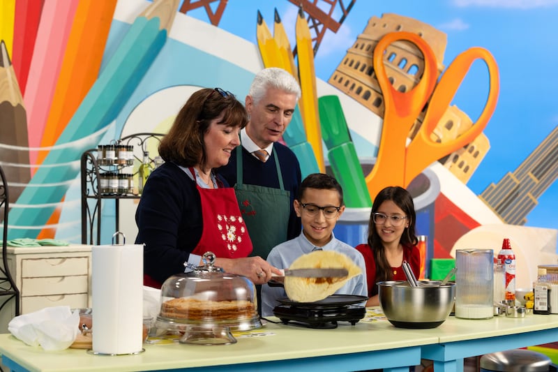 El élder Gérald Caussé y la hermana Valérie Caussé preparan crêpes con dos presentadores infantiles durante la transmisión Amigo a Amigo de septiembre de 2026.