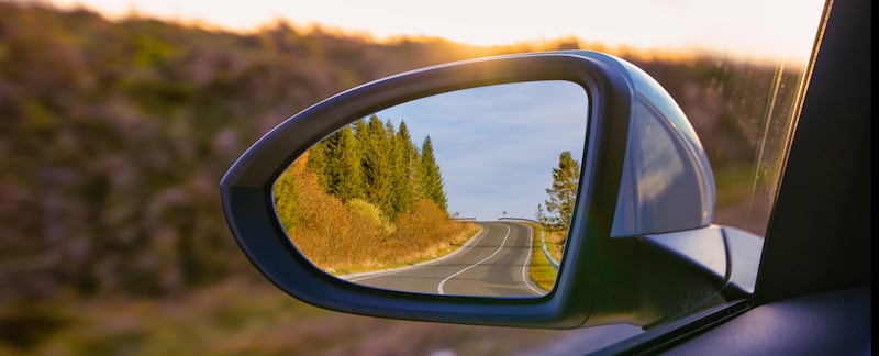 La vista de las montañas en el espejo lateral de un automóvil.