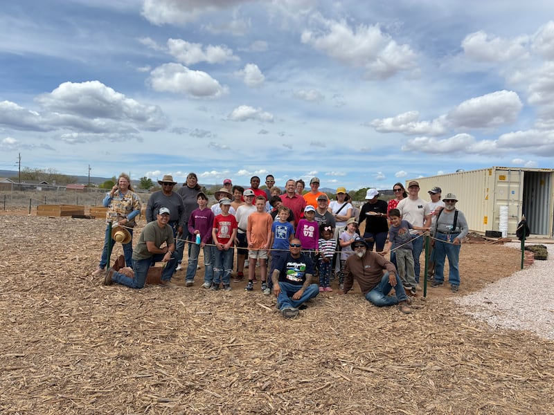 Jóvenes y adultos que ayudan en la Despensa Comunitaria y el Huerto de Esperanza sonríen para una foto después de trabajar en la preparación de nuevos huertos en Grants, Nuevo México, el 11 de abril de 2026.