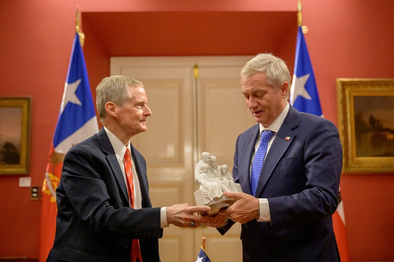 El élder David A. Bednar, del Cuórum de los Doce Apóstoles de La Iglesia de Jesucristo de los Santos de los Últimos Días, entrega al presidente de Chile, José Antonio Kast, una estatua de una familia.