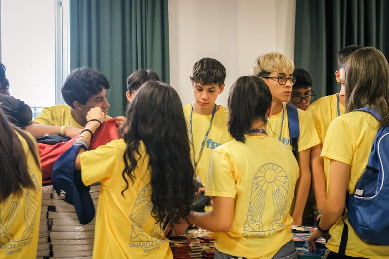 Los jóvenes arman mochilas con útiles escolares para donar a niños necesitados durante FSY en Grosseto, Italia, el 30 de julio de 2025.
