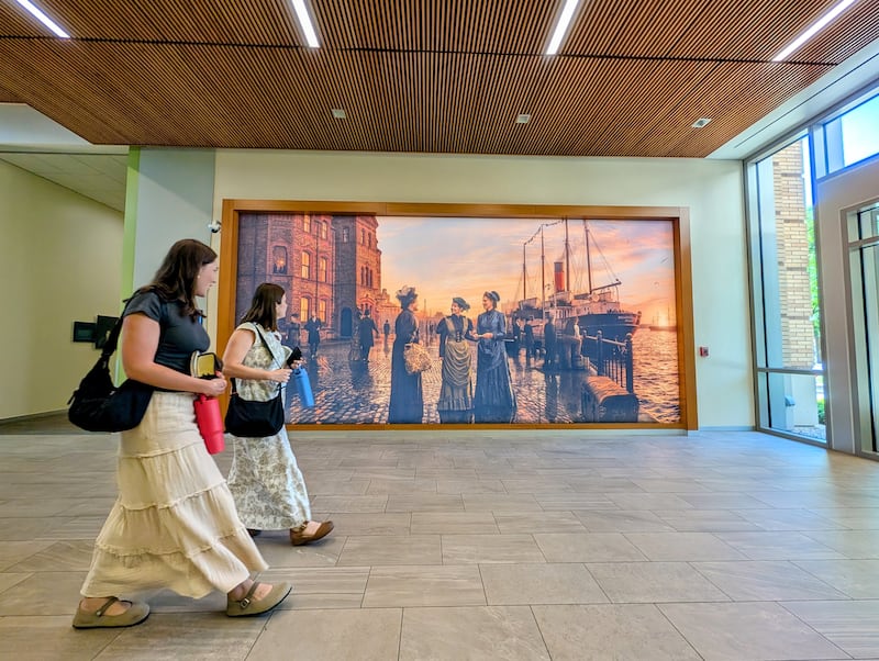 Las hermanas misioneras en el Centro de Capacitación Misional de Provo en Provo, Utah, pasan junto a una nueva instalación de arte que presenta a las primeras hermanas solteras en servir como misioneras de tiempo completo.
