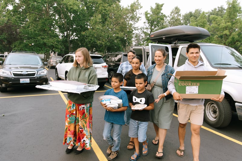 Los miembros de la Estaca Spokane Washington llevan una comida al centro de estaca para las personas afectadas por los incendios forestales en Spokane, Washington, el 2 de agosto de 2026.