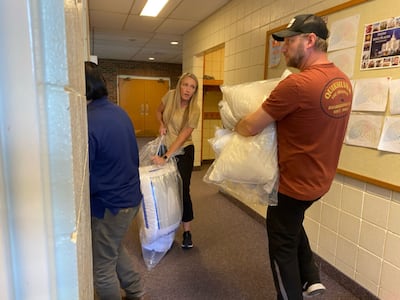 Los voluntarios Sara y Jay Sheen descargan artículos esenciales de ayuda para ucranianos donados por miembros de la región de Calgary de La Iglesia de Jesucristo de los Santos de los Últimos Días en el centro de recién llegados de Calgary en junio de 2022.