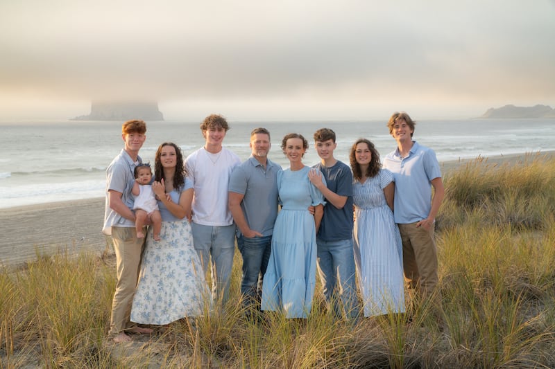 Nueve miembros de la familia Anglesey se toman una foto juntos durante un viaje a Pacific City, Oregón, en septiembre de 2025.