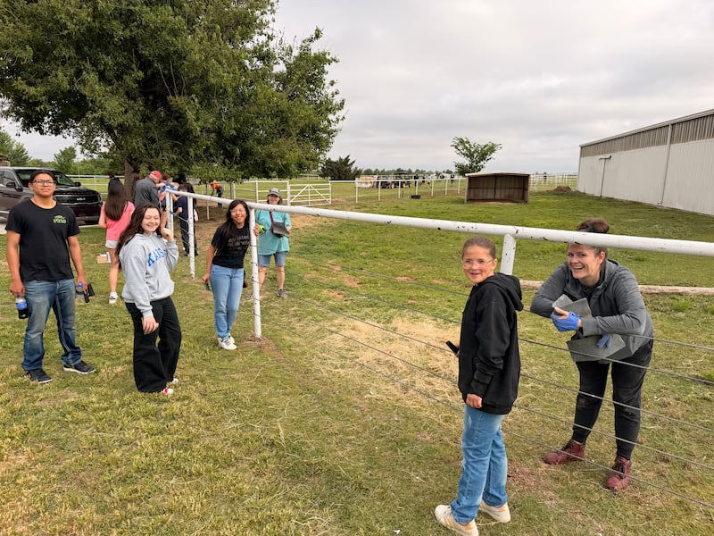 Jóvenes voluntarios pintan una cerca en el Programa de Equitación Terapéutica Savannah Station en Yukon, Oklahoma, durante el Día Mundial del Servicio Juvenil en abril de 2026.