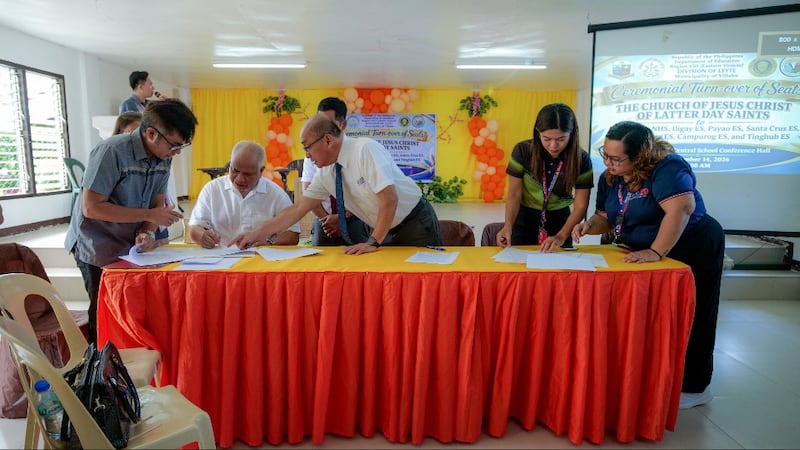 Los funcionarios firman documentos para una donación de sillas de aula y equipo médico de la Iglesia en Villaba, Leyte, Filipinas, el 14 de septiembre de 2026.