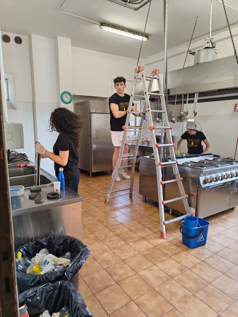 Jóvenes adultos solteros de Malta y Sicilia limpian la cocina y el equipo en Casa Scalabrini 634 en Roma, Italia.