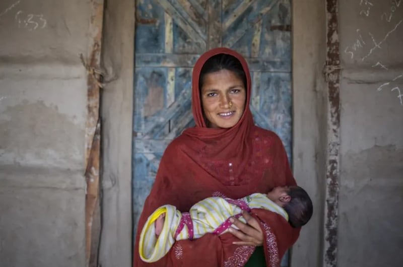 Una madre sostiene a su bebé en Pakistán.
