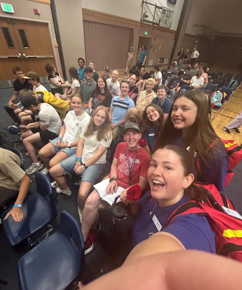 Taylor Alba, a la derecha, coordinadora de bienestar de FSY, toma una foto con los jóvenes y el personal en una conferencia de Para la Fortaleza de la Juventud en 2025.