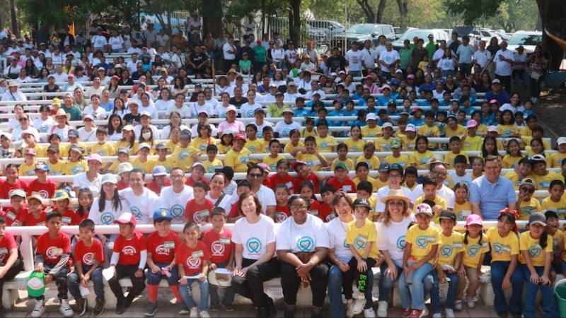La presidenta Susan H. Porter y la hermana Tracy Y. Browning posan para una foto en grupo con decenas de niños, miembros de la Iglesia y sus amigos, todos con camisetas de JustServe, mientras participan en una actividad de servicio en Tuxtla Gutiérrez, Chiapas, México, el 16 de mayo de 2026.