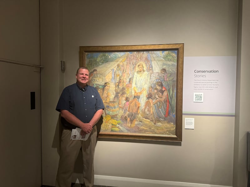David Anderson stands by "Christ Visits the Nephites" (1956) by Minerva Teichert at the Church History Museum in Salt Lake City.