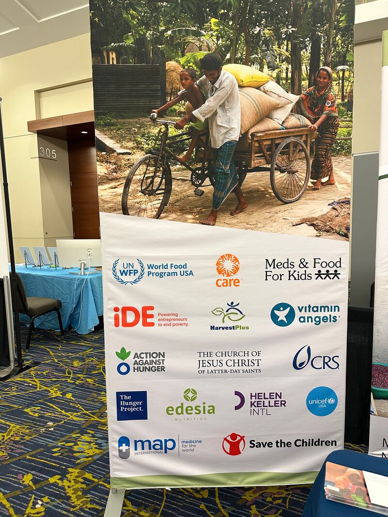 Un banner en un puesto de información de la Iglesia muestra los nombres de organizaciones globales sin fines de lucro que colaboran para ayudar en los esfuerzos de nutrición infantil en todo el mundo en el Diálogo Internacional Borlaug del Premio Mundial de la Alimentación, en Des Moines, Iowa, del 28 al 31 de octubre de 2024.