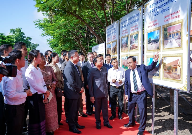 Un presidente de estaca local, el presidente Samnang Sea, muestra fotos de antes y después de los proyectos humanitarios de la Iglesia en la provincia de Tboung Khmum, Camboya, durante la ceremonia de donación el 7 de junio de 2025.