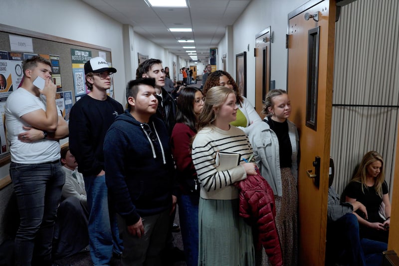 Jóvenes escuchan un devocional en el pasillo.