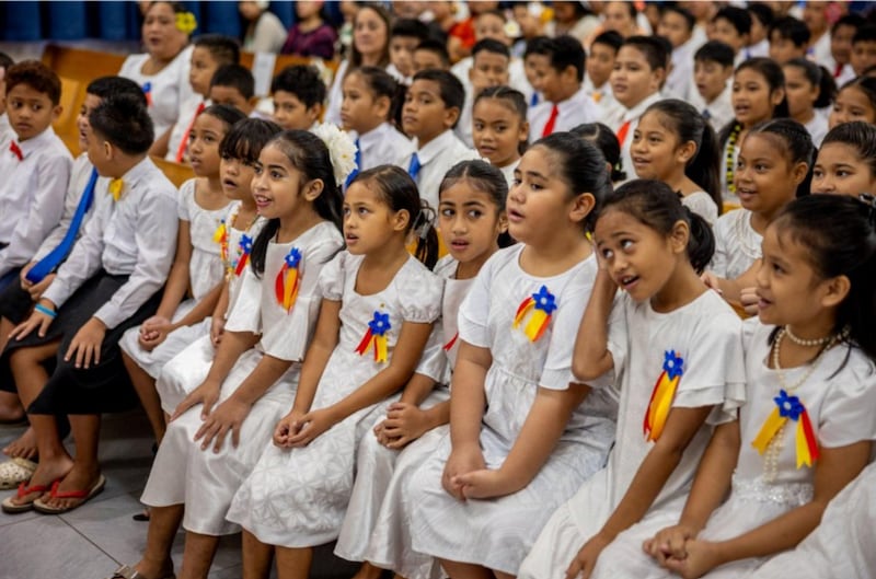 Miembros de un coro de niños se preparan para participar en una conferencia de estaca especial con el élder Gary E. Stevenson, del Cuórum de los Doce Apóstoles, en Pago Pago, Samoa Americana, el 24 de mayo de 2026.