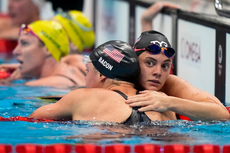 Rhyan White, de Estados Unidos, abraza a su compañera de equipo Phoebe Bacon después de la final femenina de 200 metros espalda en los Juegos Olímpicos de Verano 2020, el sábado, 31 de julio de 2021 en Tokio, Japón.