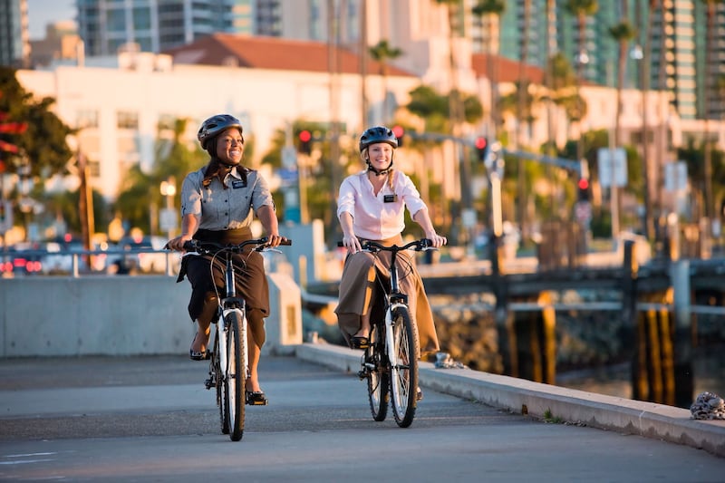 Dos misioneras de hermanas usando cascos y viajando en bicicleta.
