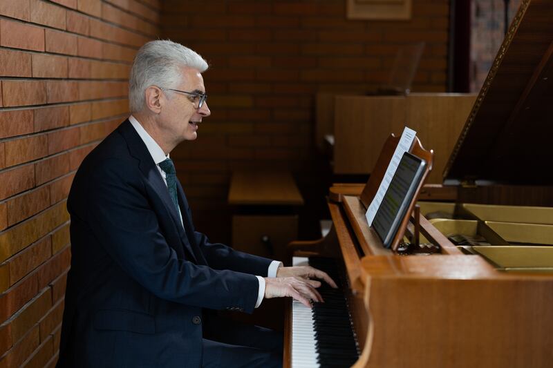 El élder Gérald Caussé, del Cuórum de los Doce Apóstoles, toca el piano el 23 de febrero de 2026 en el centro de estaca de París, Francia, en Versalles, Francia, donde sirvió como presidente de estaca hace más de 20 años.