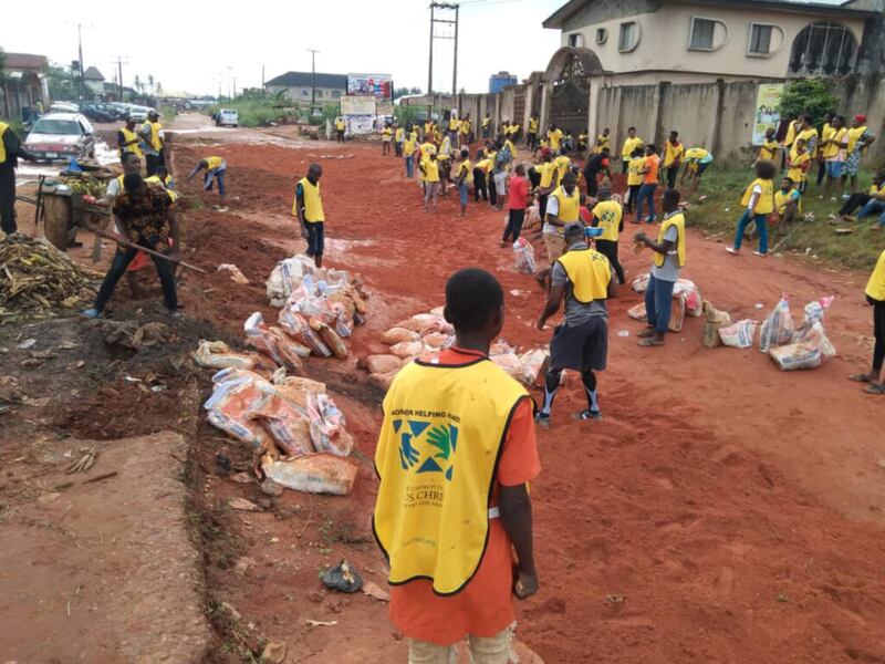 Los voluntarios utilizan bolsas de arena y laterita para arreglar las partes deterioradas de la carretera Adolor Road, en Benin-City, Nigeria, durante las actividades del Día de Servicio en todo África 2021 de La Iglesia de Jesucristo de los Santos de los Últimos Días, el 21 de agosto de 2021.