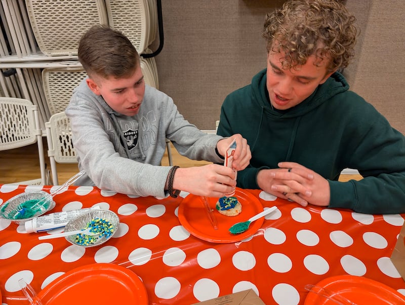 Un participante y un consejero de jóvenes decoran galletas durante el programa de actividades para personas con discapacidad en Las Vegas, Nevada, en febrero de 2026.