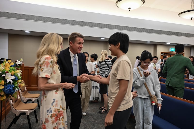 El presidente general de los Hombres Jóvenes, Timothy L. Farnes, y su esposa, la hermana Linsey Farnes, saludan a un joven después de un devocional como parte de una asignación de ministerio a países de Asia, del 21 al 31 de mayo de 2026.