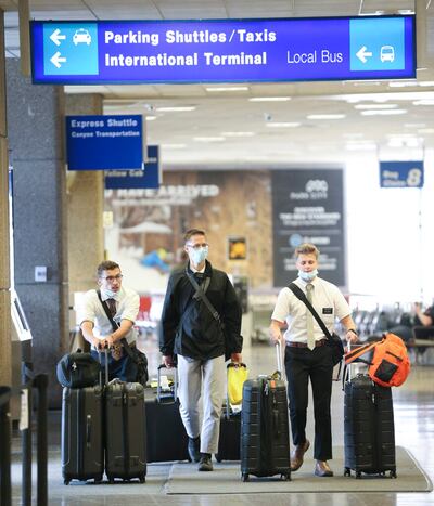 Los élderes Noah Deckard, Nathan Budge y Jackson Nielsen recogen su equipaje mientras cientos de misioneros de La Iglesia de Jesucristo de los Santos de los Últimos Días regresan de las Filipinas al Aeropuerto Internacional de Salt Lake City el domingo, 22 de marzo de 2020.