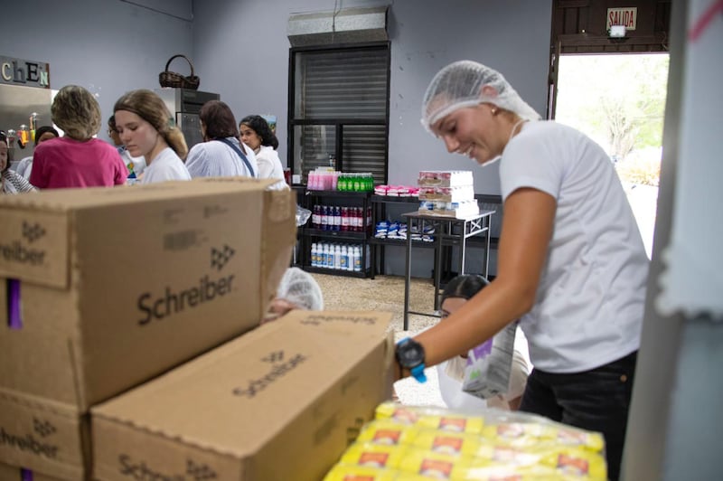 Jóvenes empacan alimentos durante una actividad de servicio comunitario en Naguabo, Puerto Rico, el sábado 16 de mayo de 2026.