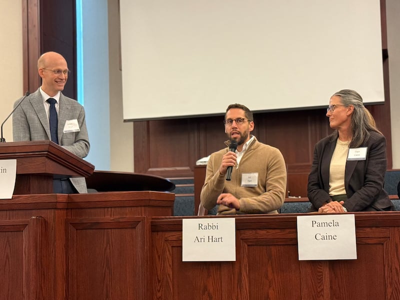 Justin Dyer de la Universidad Brigham Young, el rabino Ari Hart y Pamela Caine se sientan en la tribuna y se dirigen a la audiencia durante una reunión interreligiosa en Chicago, Illinois, el 14 de octubre de 2026.