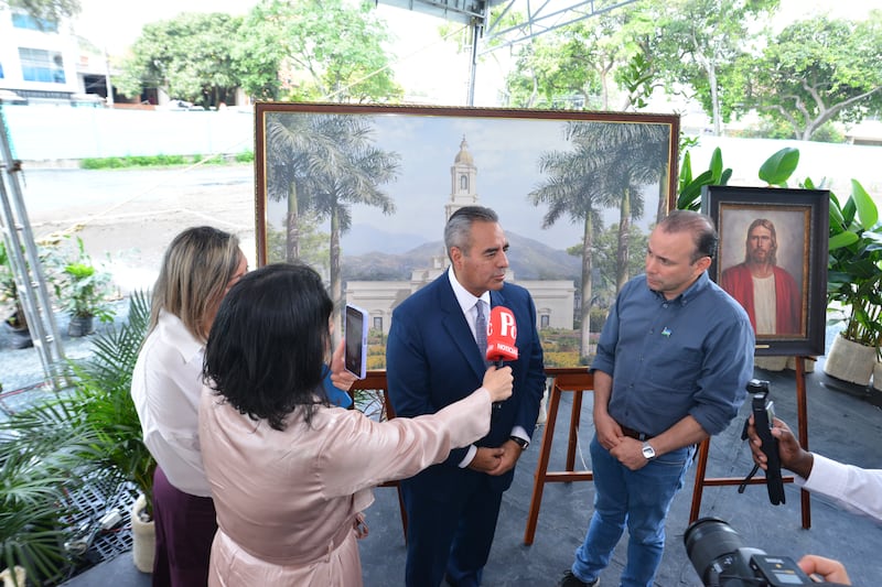 Representantes de los medios de comunicación entrevistando al Élder Jorge T. Becerra con micrófonos.