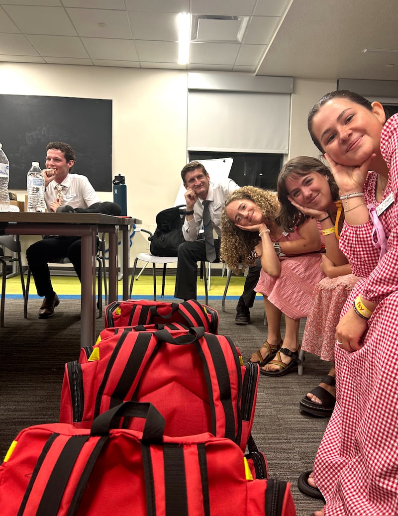 Taylor Alba se toma una foto con otros miembros del personal en una conferencia de Para la Fortaleza de la Juventud en 2025.