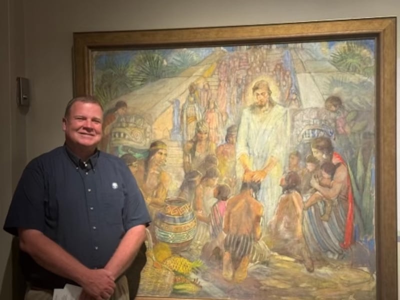 David Anderson stands by "Christ Visits the Nephites" (1956) by Minerva Teichert at the Church History Museum in Salt Lake City