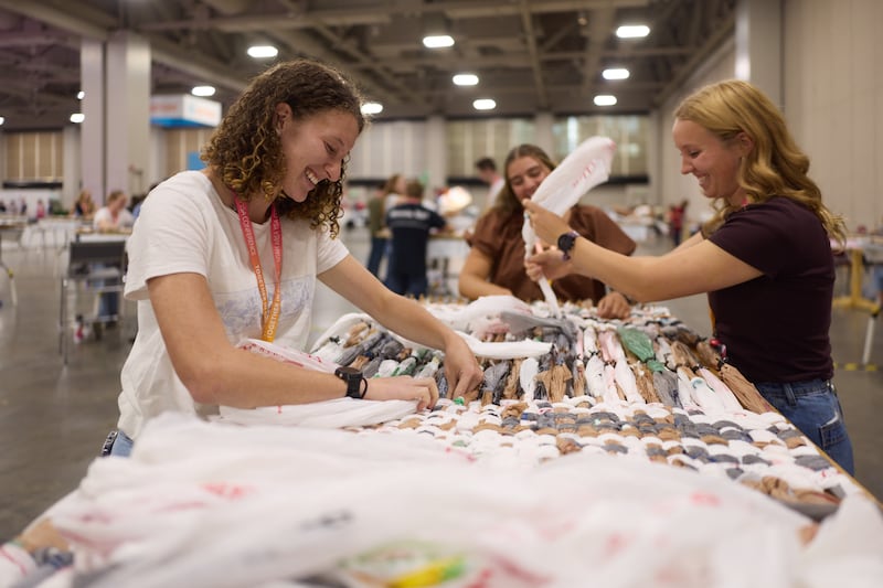 Varios asistentes participan en un proyecto de servicio en la Conferencia de Adultos Jóvenes del Área de Utah de 2026 en el Centro de Convenciones Salt Palace en Salt Lake City el viernes, 14 de agosto de 2026.