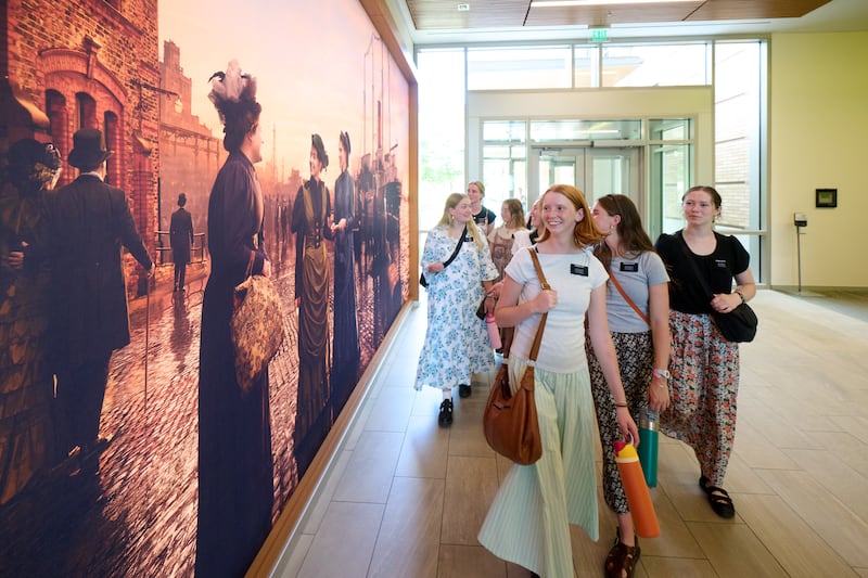 Las misioneras caminan junto a un nuevo mural que representa a las primeras misioneras solteras de esta dispensación en el Centro de Capacitación de Misiones de Provo en Provo, Utah, 19 de junio de 2026.