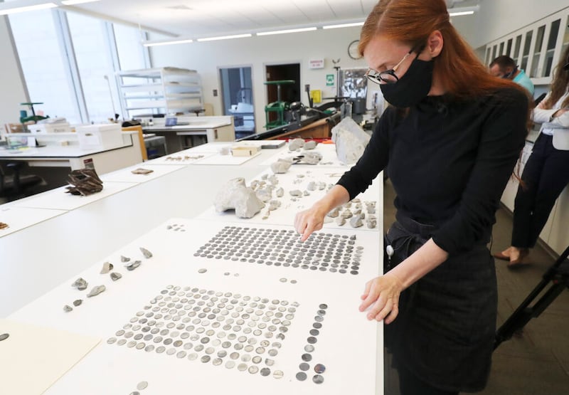 Emiline Twitchell, conservadora de la Biblioteca de Historia de la Iglesia, observa monedas halladas en la piedra angular y cápsula del tiempo del Templo de Salt Lake en la Biblioteca de Historia de la Iglesia en Salt Lake City, el martes, 14 de julio de 2020.