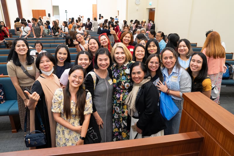 La presidenta general de la Sociedad de Socorro, Camille N. Johnson, se toma una foto con hermanas de la Sociedad de Socorro en un centro de reuniones en Bangkok, Tailandia.