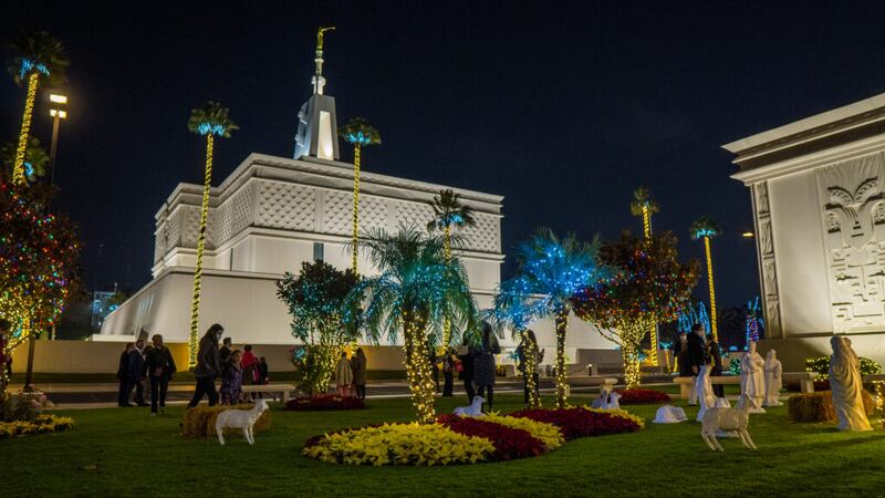 La gente camina por los terrenos del Templo de la Ciudad de México, donde se iluminaron las luces navideñas el 28 de noviembre de 2021.