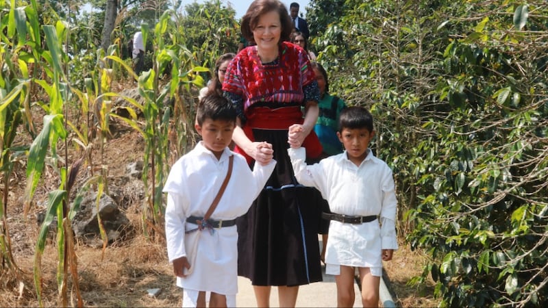 La presidenta Susan H. Porter es guiada por dos niños a través de un campo de maíz en Chenalhó, Chiapas, México, en mayo de 2026.