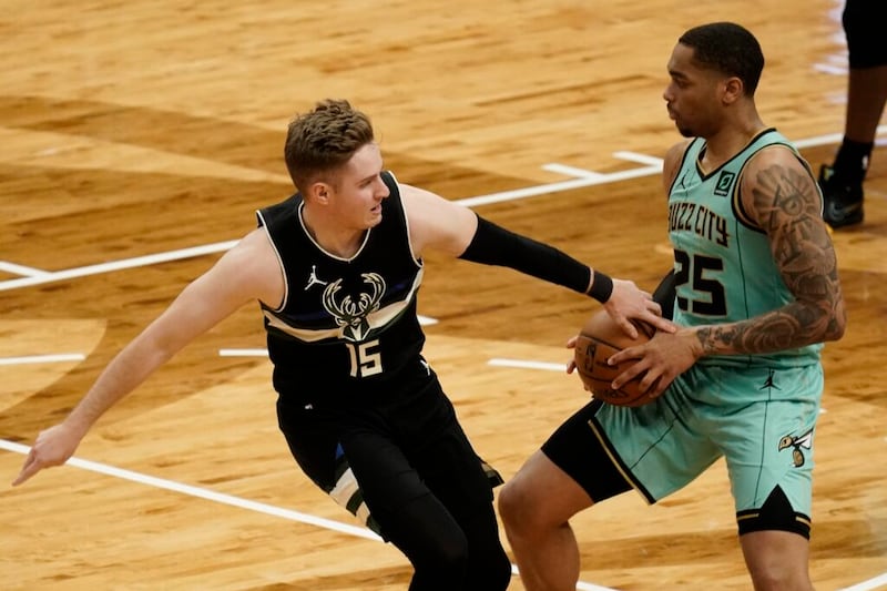 Sam Merrill de los Milwaukee Bucks intenta robarle el balón a P.J. Washington de los Charlotte Hornets durante la primera mitad de un juego de baloncesto de la NBA, el viernes, 9 de abril de 2021 en Milwaukee. (Foto AP / Morry Gash)