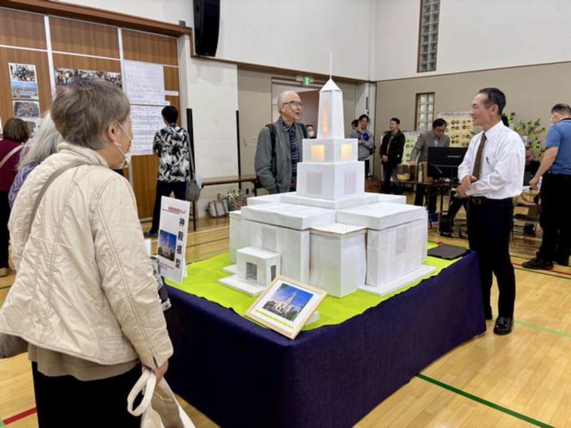 Personas observan un modelo de papel del futuro Templo de Osaka, Japón, exhibido en una feria de historia familiar en Kioto, Japón, el 25 de octubre de 2025.