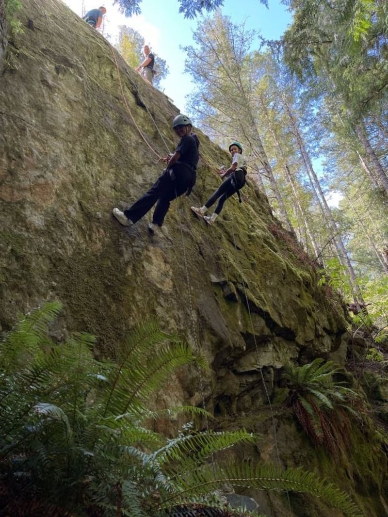 Las mujeres jóvenes descienden en rápel por un acantilado en la isla de Vancouver Sur, Canadá, durante el campamento de Mujeres Jóvenes en agosto de 2025.
