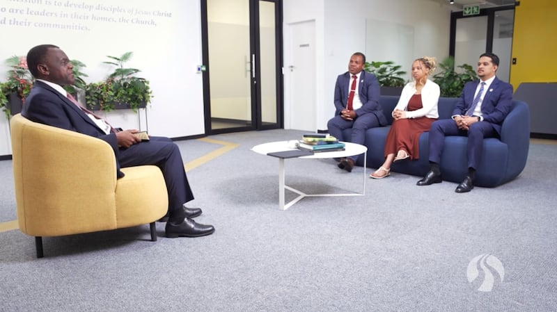 El élder Edward Dube conversa con tres estudiantes de BYU–Pathway Worldwide durante una transmisión de un devocional el viernes, 5 de junio de 2026.