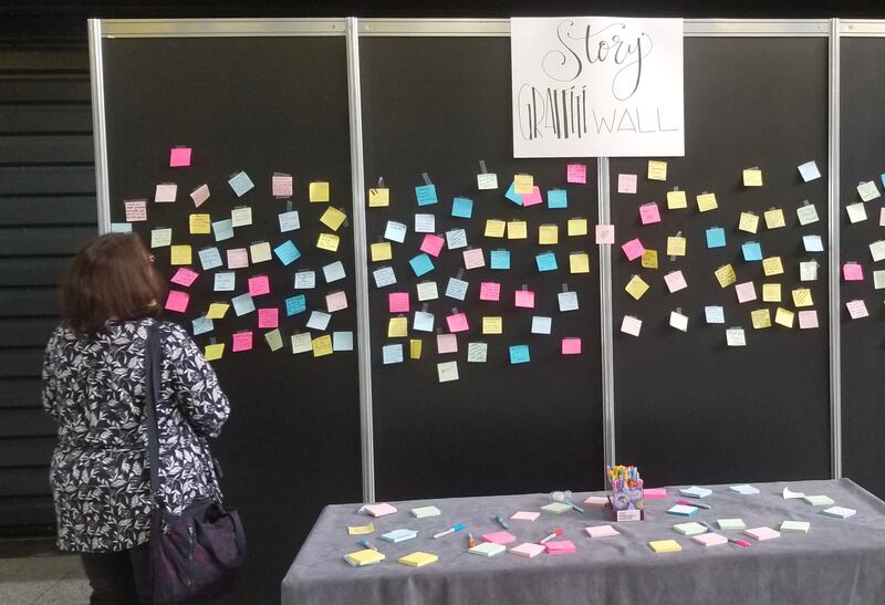 Mientras que RootsTech Londres fomentaba la recopilación de historias de los antepasados, un participante escudriña el “Tablero de grafiti de historias” en el London ExCel Center el viernes, 25 de oct. de 2019.