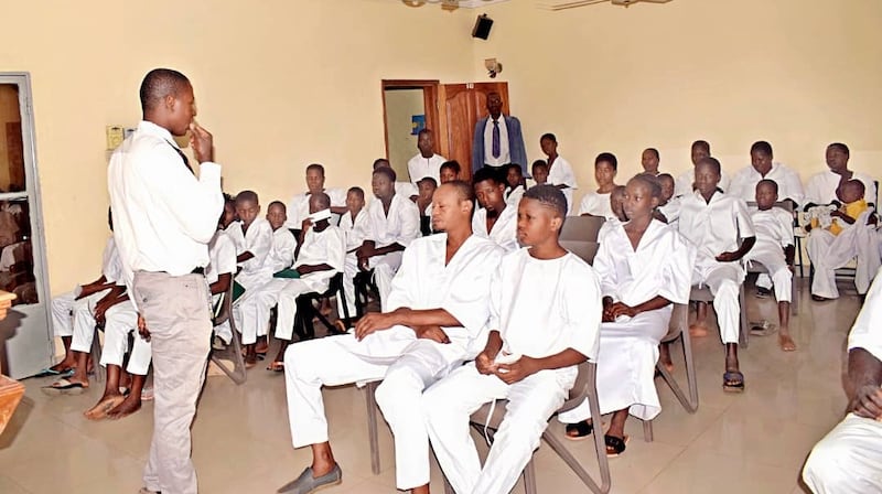 Candidatos al bautismo vestidos de blanco esperan en la capilla su turno para ser bautizados en una pila bautismal afuera en Bamako, Mali, el 18 de abril de 2026.