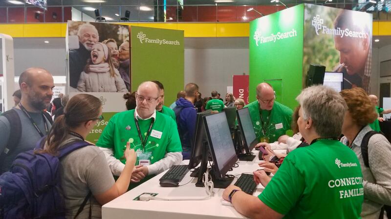 Participantes del RootsTech Londres y asistentes de FamilySearch se reúnen en el puesto de FamilySearch en el centro de exhibiciones London ExCel, el jueves 24 de octubre de 2019.