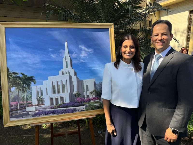 El élder Ronald M. Barcellos, Setenta Autoridad General y consejero en la presidencia del Área Brasil, y su esposa, la hermana Karin Barcellos, están cerca de una representación arquitectónica del Templo de Santos Brasil en la ceremonia de colocación de la primera piedra el sábado, 1 de agosto de 2026, en Santos, Brasil.