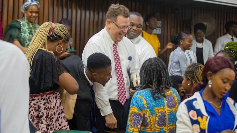 El élder Clark G. Gilbert saluda a estudiantes y visitantes en un devocional en Lagos, Nigeria, el 14 de enero de 2024.